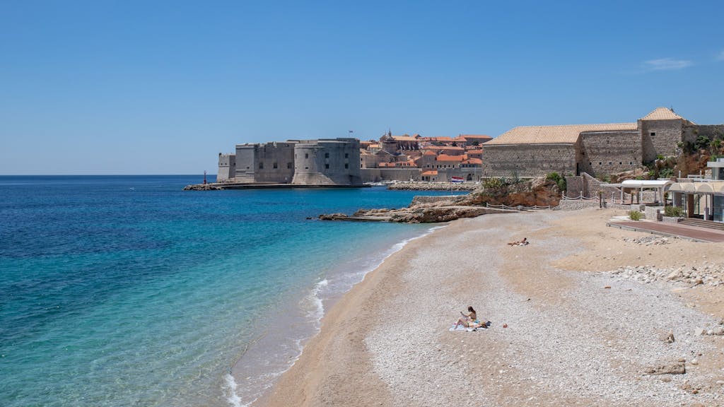 Vier Personen sonnen sich an der Adria an einem Strand, hier im Mai 2020.