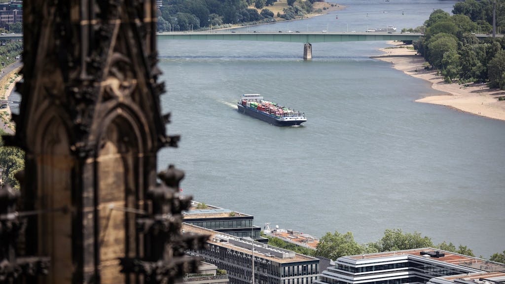 Ein Transport-Schiff fährt auf dem Rhein. Im Vordergrund ist der Dom, im Hintergrund die Zoobrücke zu sehen.
