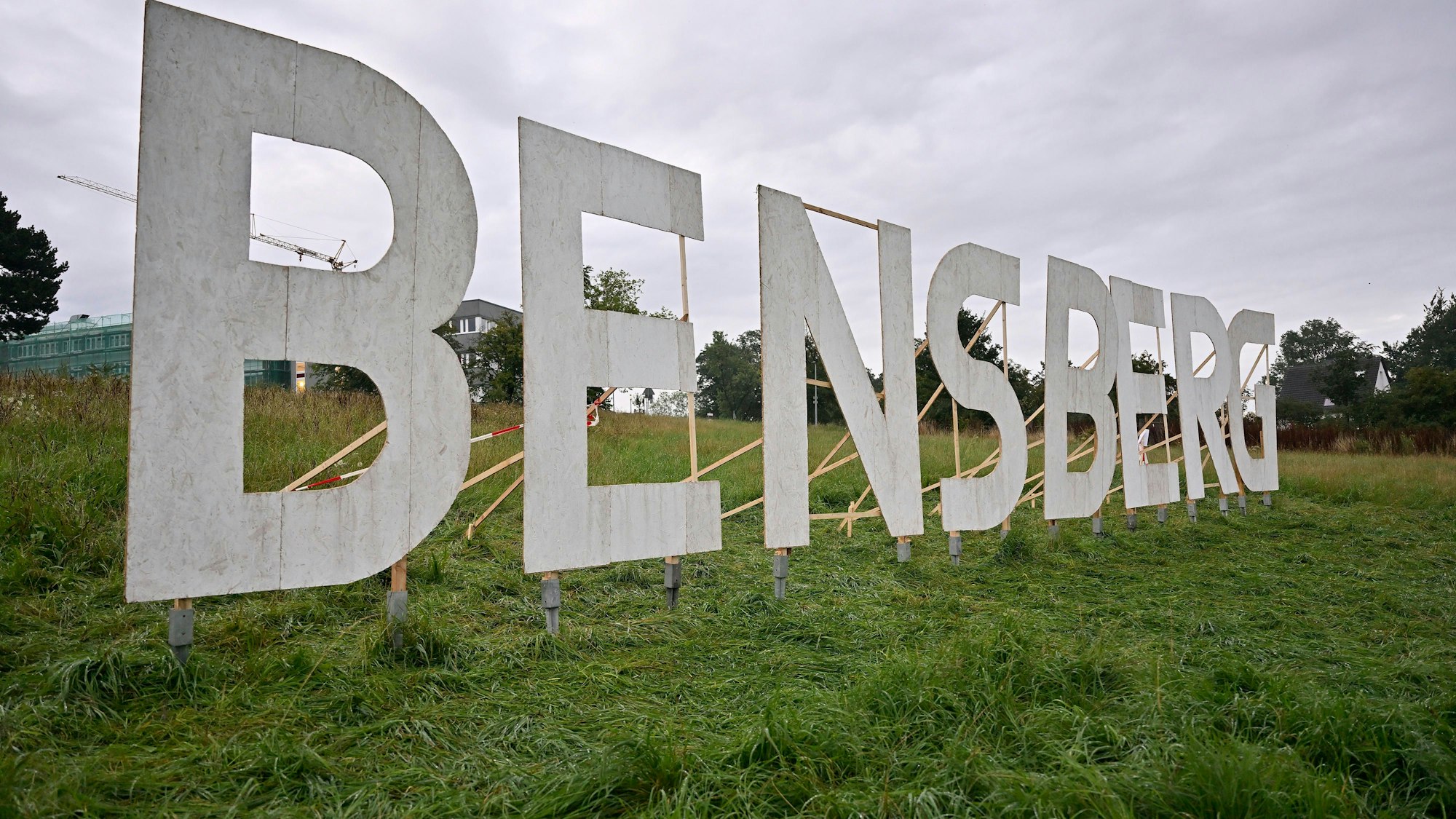 Au einer Wiese sind acht übergroße Buchstaben BENSBERG aufgestellt.