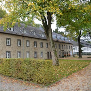 Ein historisches Gebäude mit dem Schriftzug Altes Brauhaus. Lindenbäume, davor eine Hecke.