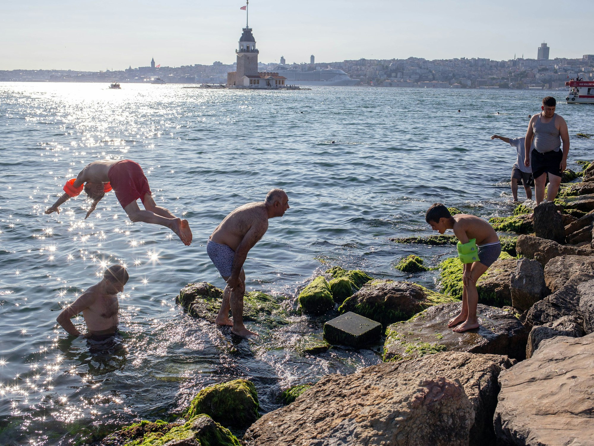 Menschen springen am Bosporus ins Meer, um sich abzukühlen.