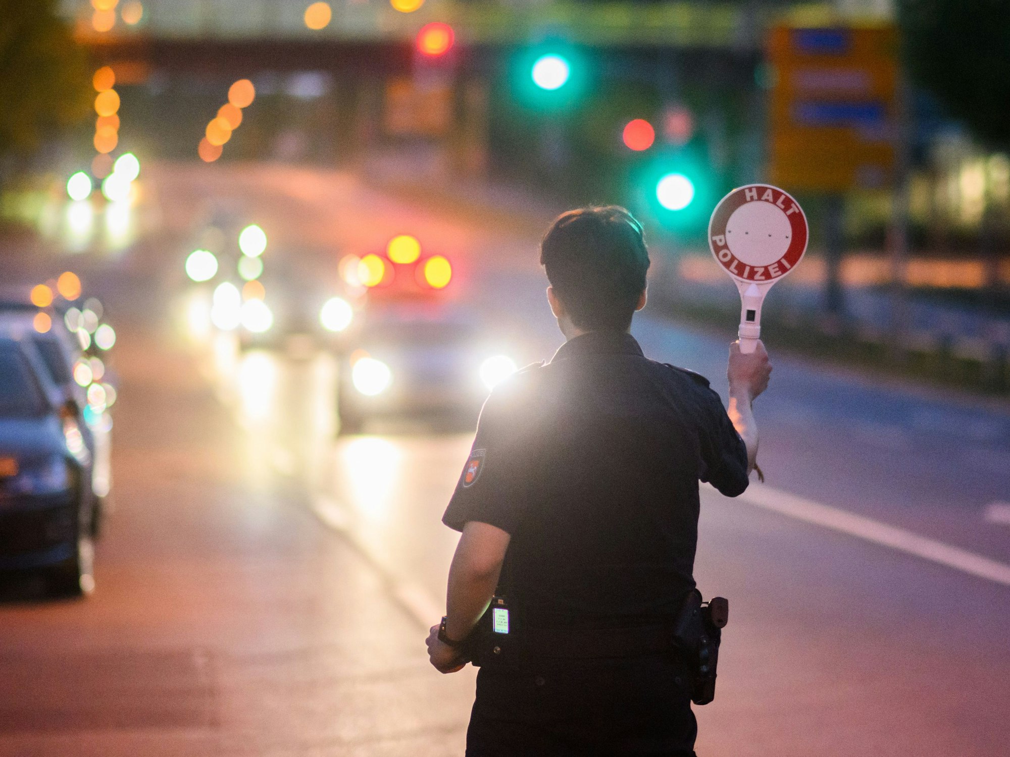 Ein Polizist stoppt ein Fahrzeug bei einer Kontrolle am Expo-Park.