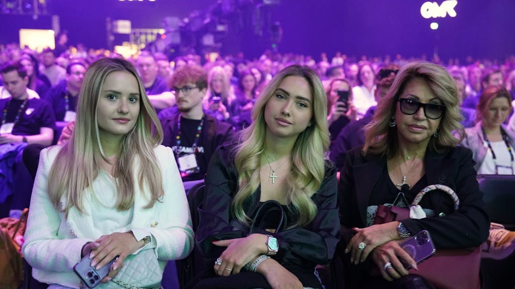 Davina (l-r) und Shania Geiss sitzen neben ihrer Mutter Carmen Geiss, (Mai 2023) während des Auftritts von Robert Geiss auf der Bühne der Digital-Messe OMR in den Messehallen.