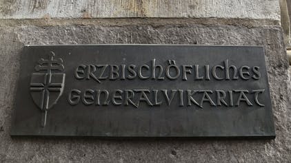Bronzeschild am Hauptgebäude des Erzbischöflichen Generalvikariats  in der Marzellenstraße. Foto: Csaba Peter Rakoczy