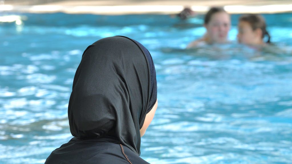 Eine Frau im Burkini im Schwimmbad.