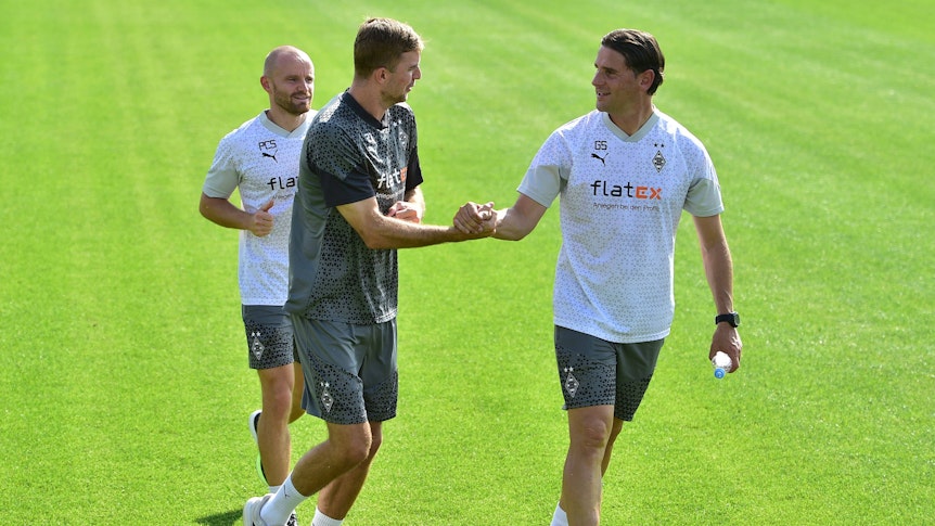 Gerardo Seoane (r.) schlägt am 14. August 2023 mit Christoph Kramer (M.) auf dem Trainingsplatz von Borussia Mönchengladbach ein.
