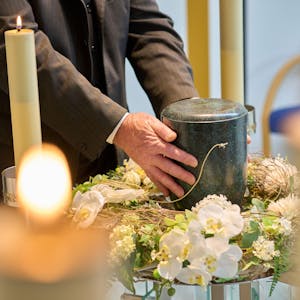 Ein Bestatter platziert eine Urne im Andachtsraum des Krematoriums Dachsenhausen.