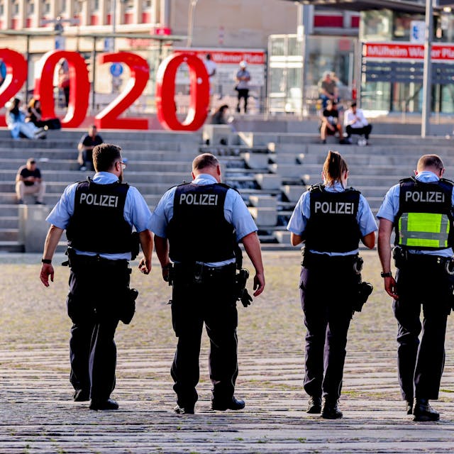 Vier Polizistinnen und Polizisten laufen über den Wiener Platz in Köln.