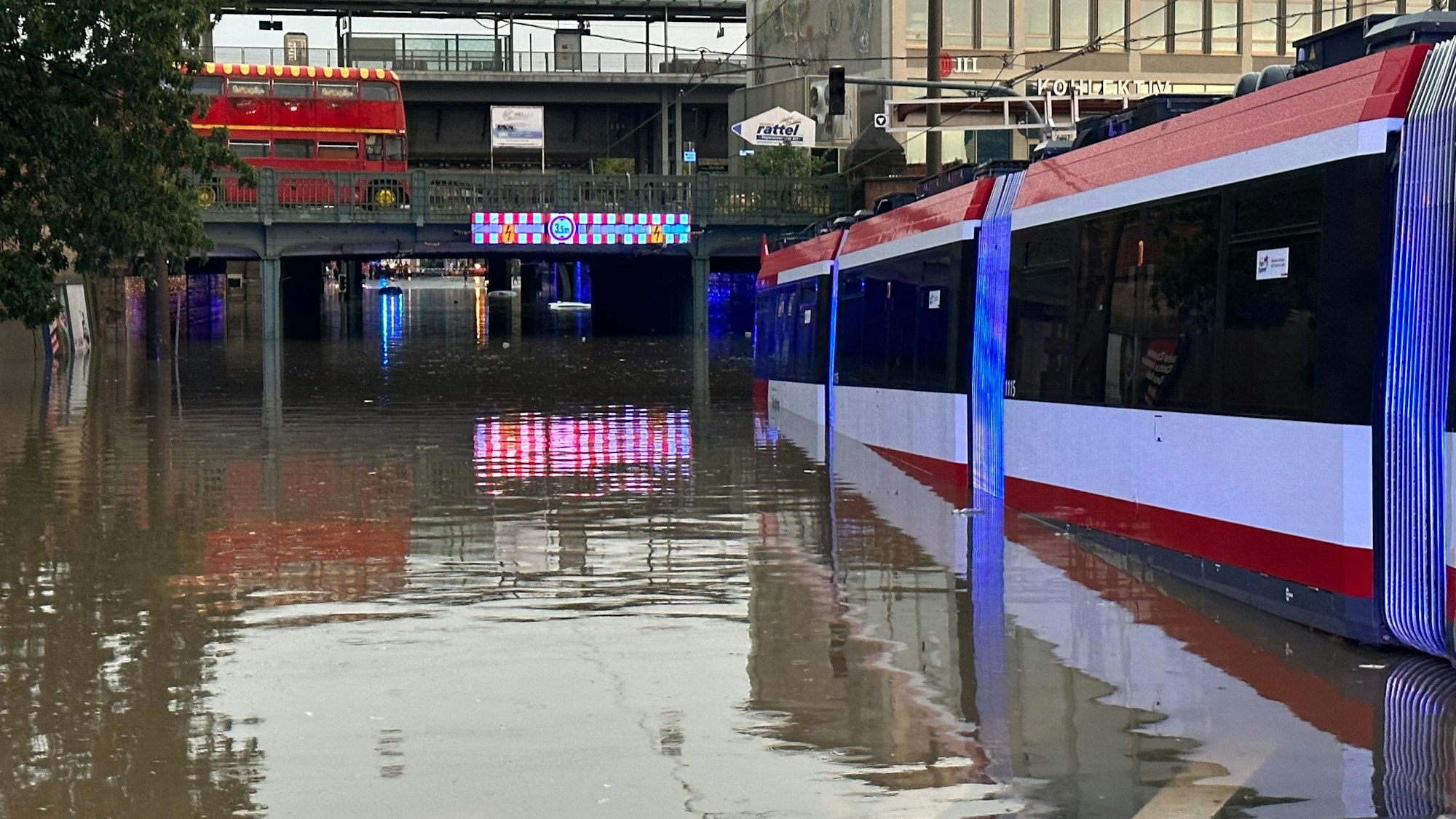 Straßenbahn steht in Nürnberg in einer überschwemmten Straße an einer Unterführung nach einer Unwetter.