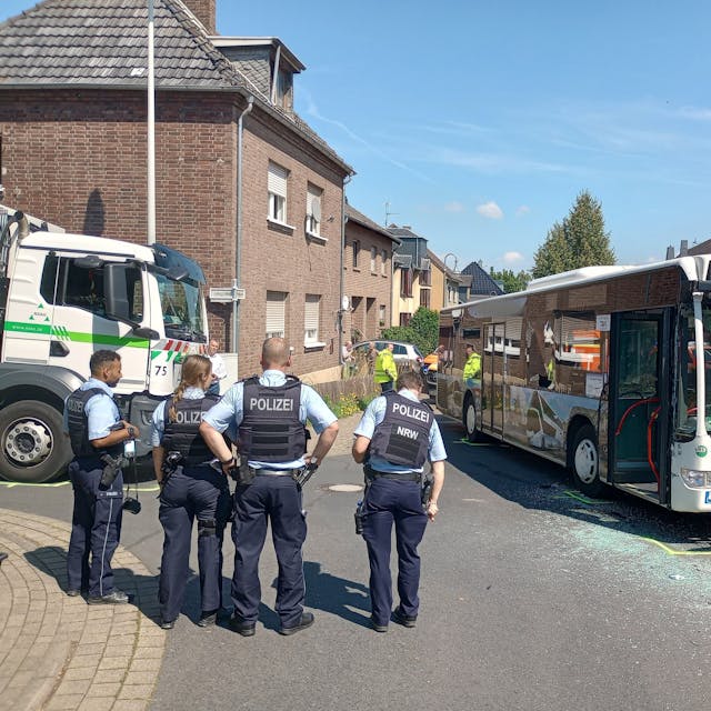 An einer Unfallstelle in Bornheim stehen ein Bus und ein Müllwagen.