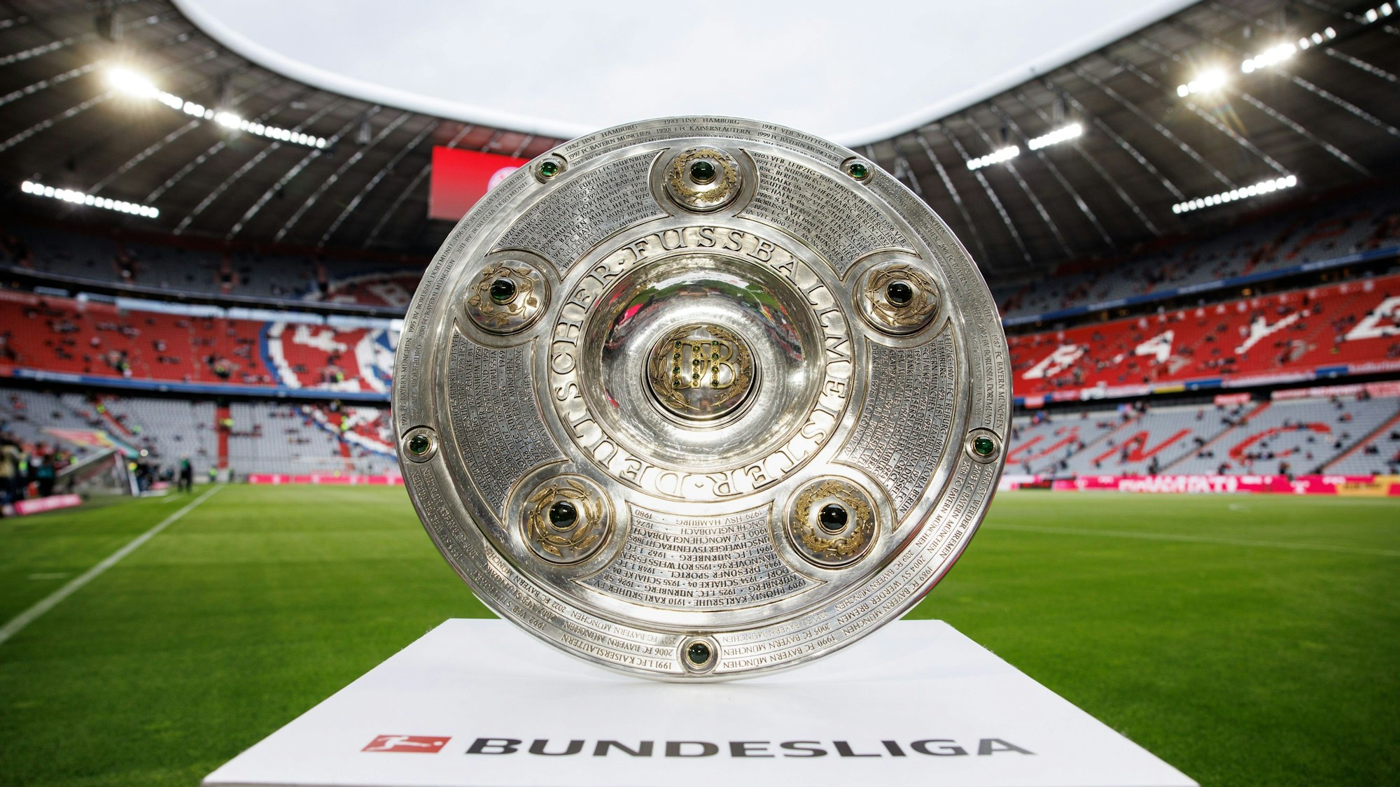 Foto von der Meisterschale der Fußball-Bundesliga, die auf einem Podest im Stadion in München ausgestellt ist.