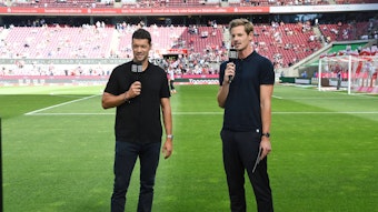 Ex-Nationalspieler Michael Ballack (l.) und Moderator Alex Schlüter stehen am 7. August 2022 vor einem Bundesliga-Spiel im Kölner Stadion.
