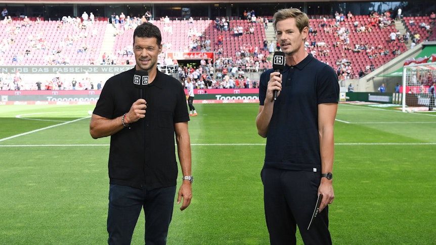 Ex-Nationalspieler Michael Ballack (l.) und Moderator Alex Schlüter stehen am 7. August 2022 vor einem Bundesliga-Spiel im Kölner Stadion.