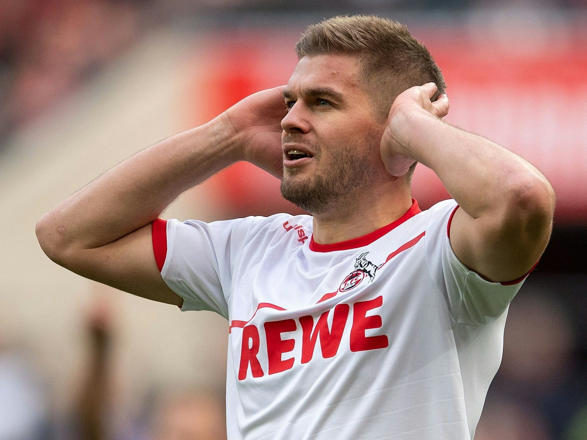 Simon Terodde vom 1. FC Köln jubelt, indem er seine geöffneten Hände an die Ohren hält.