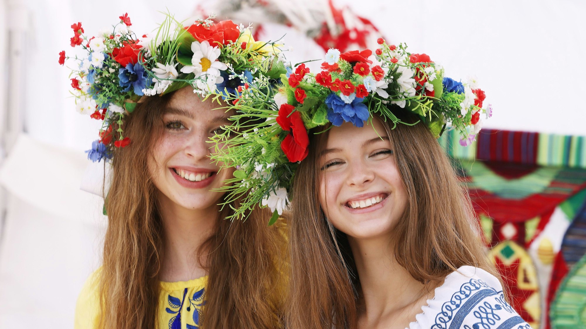 Zwei junge Frauen mit Blumenkopfschmuck schauen in die Kamera. Sie sind Teil des Ukraine-Tags in Köln.