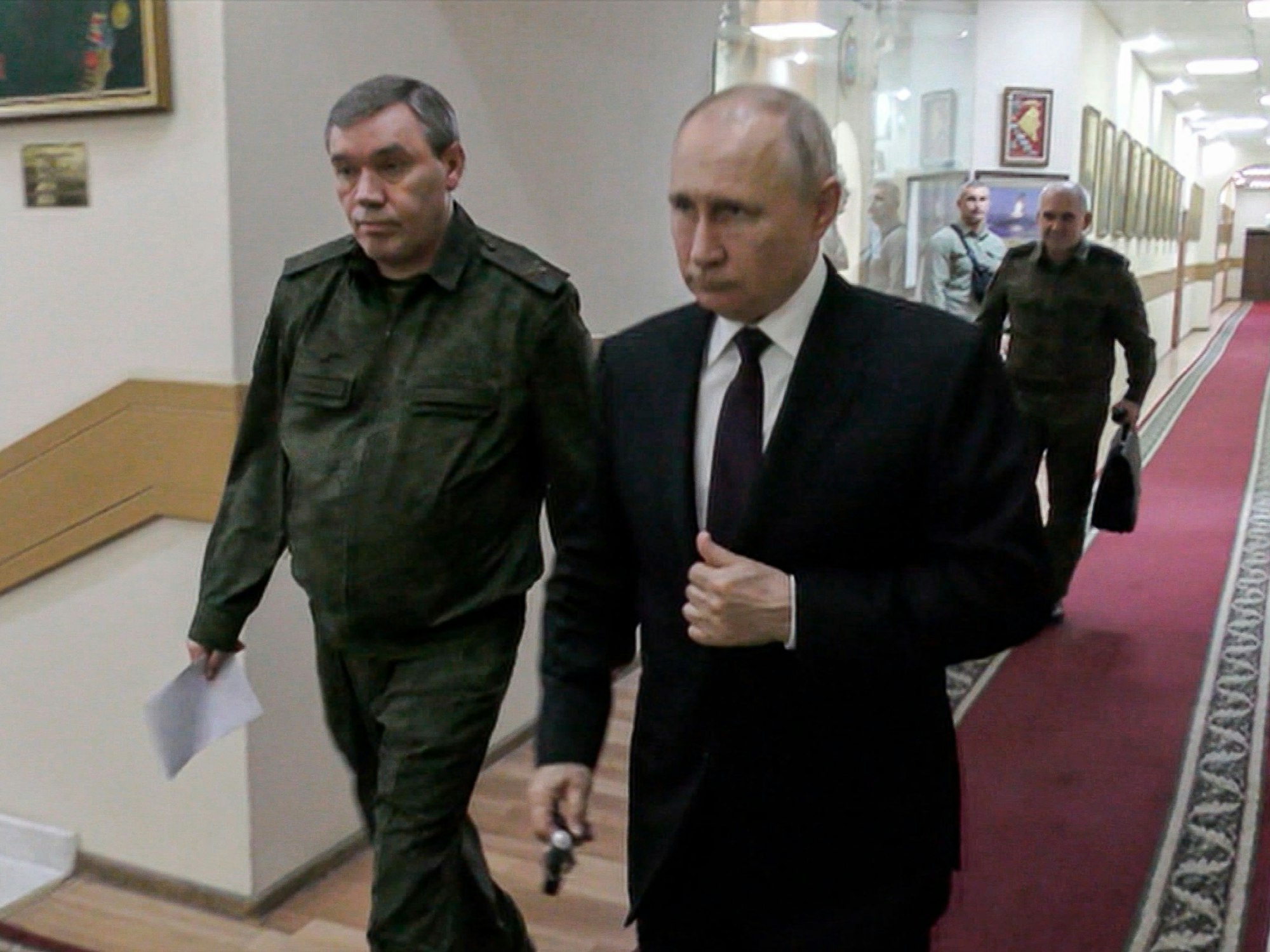 Dieses vom russischen Fernsehen RU-RTR zur Verfügung gestellten Videostandbild zeigt Russlands Präsident Wladimir Putin (r.) und Waleri Gerassimow, seinen Generalstabschef, die zu einem Treffen mit hochrangigen Kommandeuren gehen.