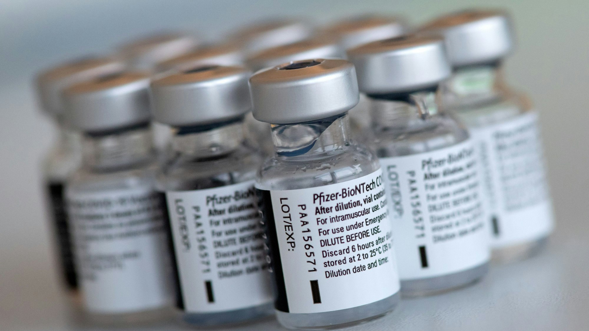 Leere Ampullen des Impfstoffs von Biontech/Pfizer gegen das Corona-Virus SARS-CoV-2 stehen in einem Impfzentrum nach der Vorbereitung der Spritzen auf einem Tisch.