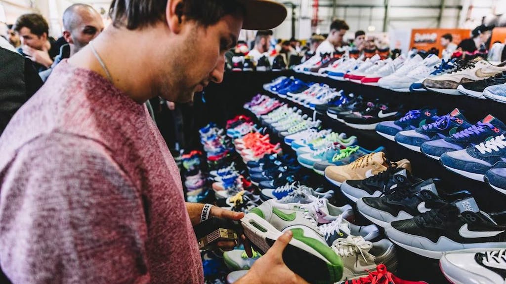 Ein Mann steht vor einem Sneaker bei der „Sneakerness“.