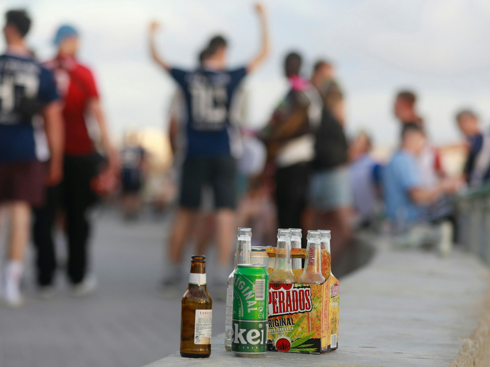 Feiernde auf Mallorca, im Vordergrund mehrere Bierflaschen.