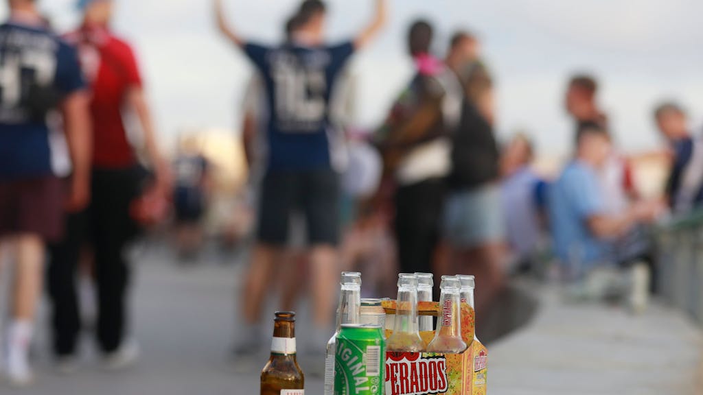 Feiernde auf Mallorca, im Vordergrund mehrere Bierflaschen.