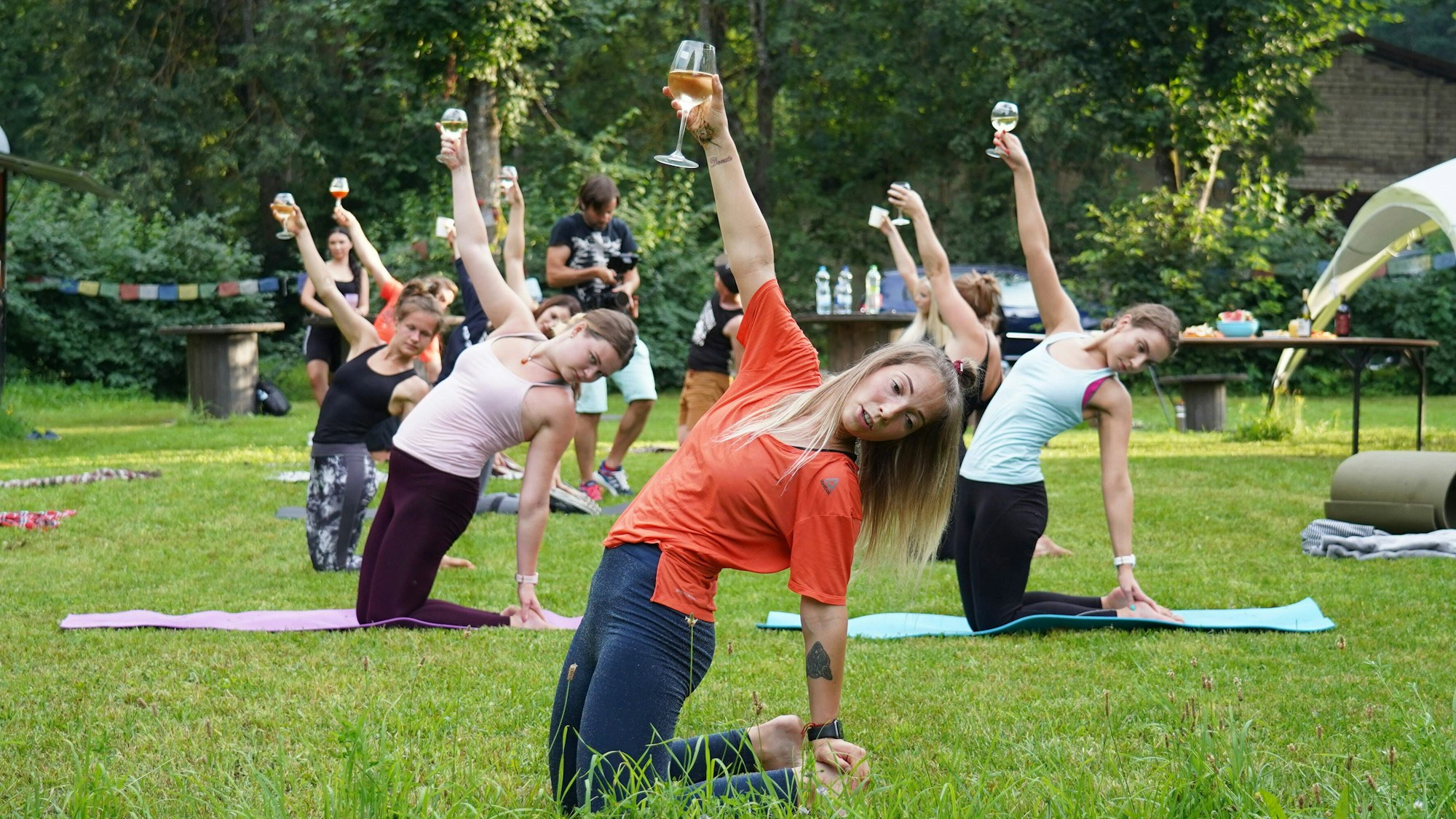 Frauen bei einer Yogaübung mit einem Glas Wein in Riga