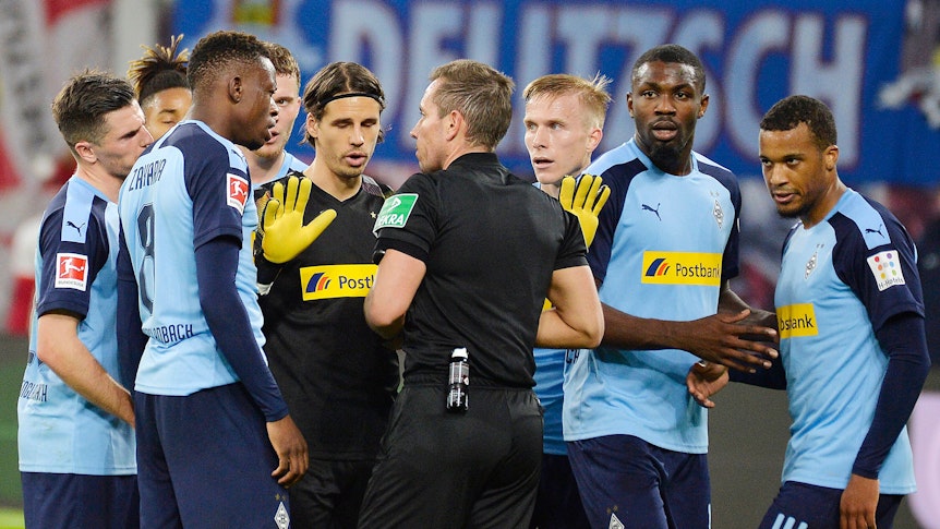Das Spieler von Borussia Mönchengladbach diskutieren am 1. Februar 2020 nach einem Platzverweis gegen Alassane Plea mit Schiedsrichter Tobias Stieler.