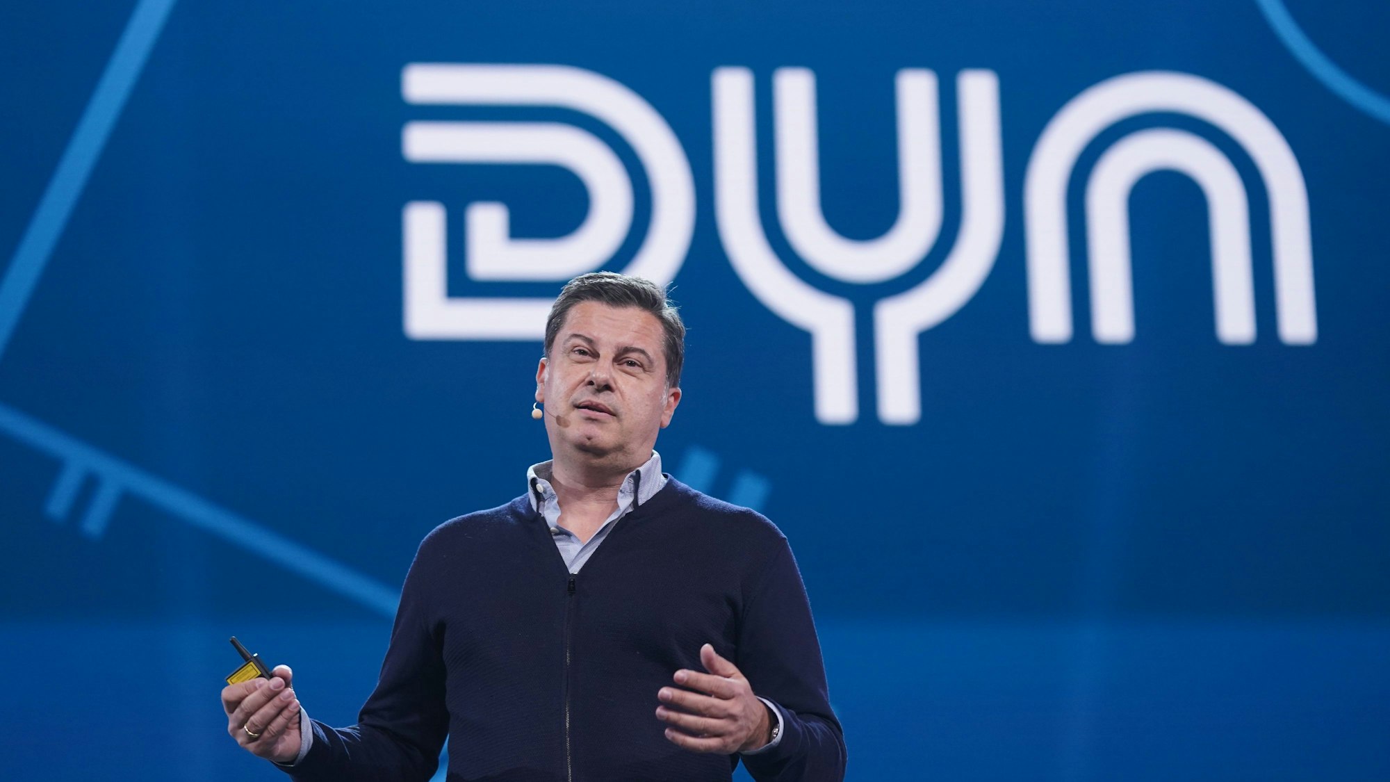Dyn-Gründer Christian Seifert bei einer Pressekonferenz vor dem Dyn-Logo.