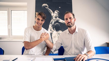 Handballer Julian Köster und VfL-Geschäftsführer Christoph Schindler sitzen nebeneinander und schlagen mit den Händen ein.