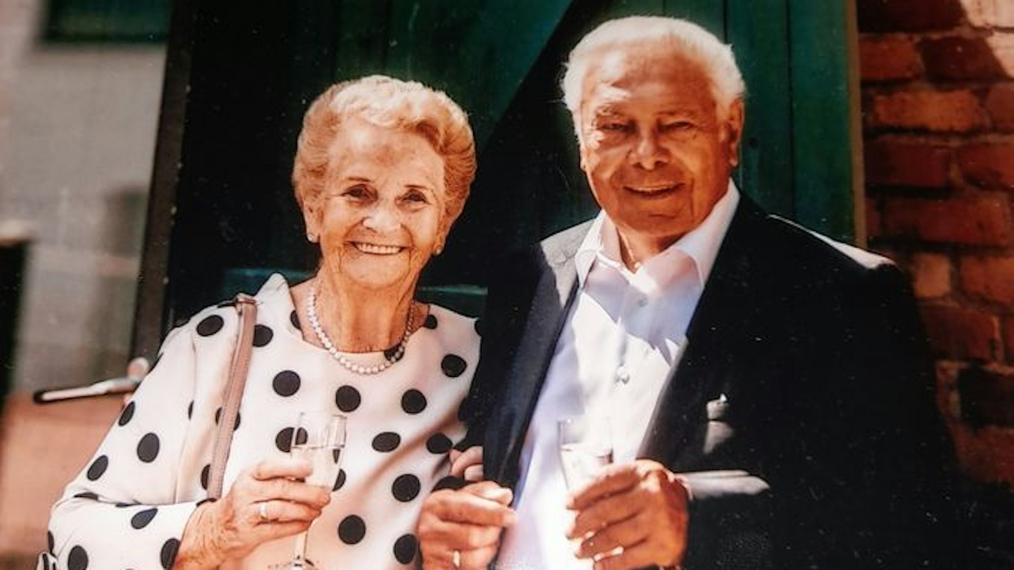 Anita und Willi Stettendorf halten Sektgläser in der Hand und lächeln.