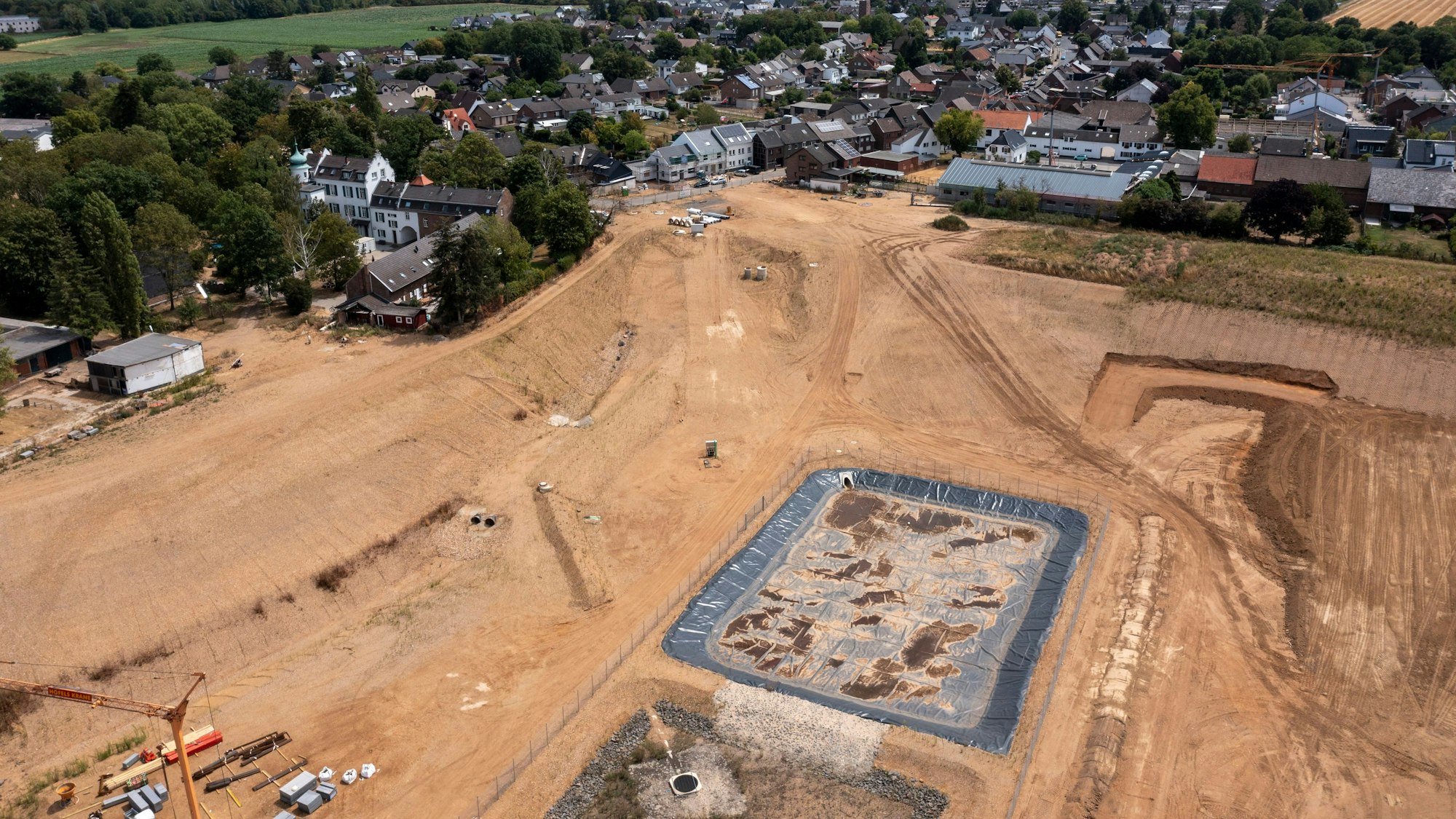Das Bild zeigt eine Luftaufnahme der Kiesgrube in Erftstadt-Blessem. Die Flut riss im Juli 2021 Häuser und Autos mit in die Grube.