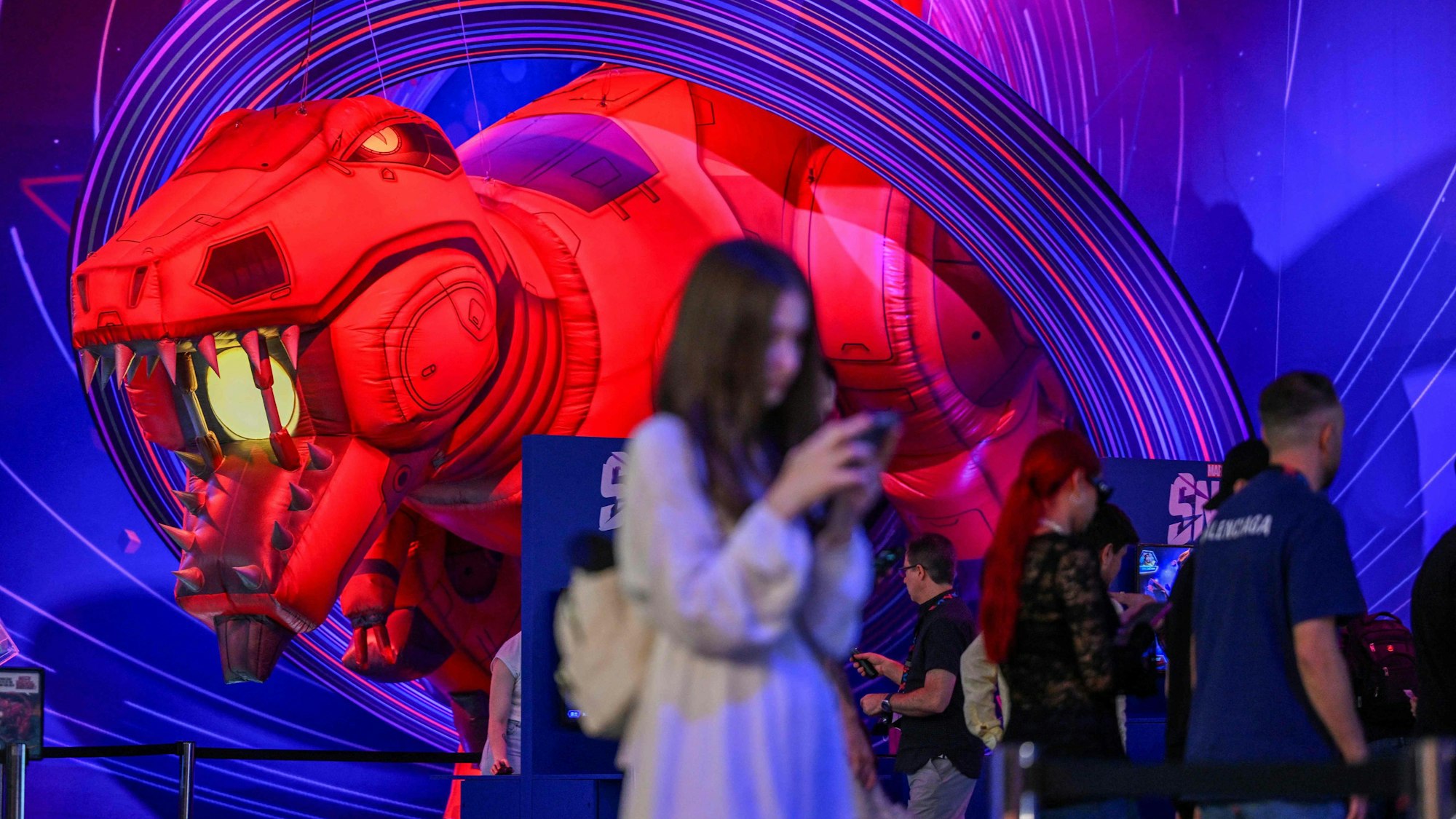 Eine Besucherin steht neben der Figur aus einem Marvel-Snap-Spiel.