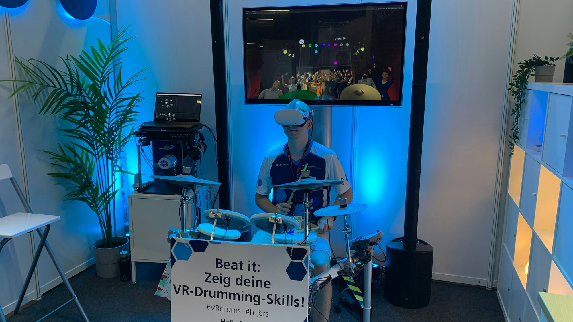 David Reiter spielt auf einem virtuellen Schlagzeug. Eine VR-Brille vor seinen Augen simuliert ihm ein Publikum.