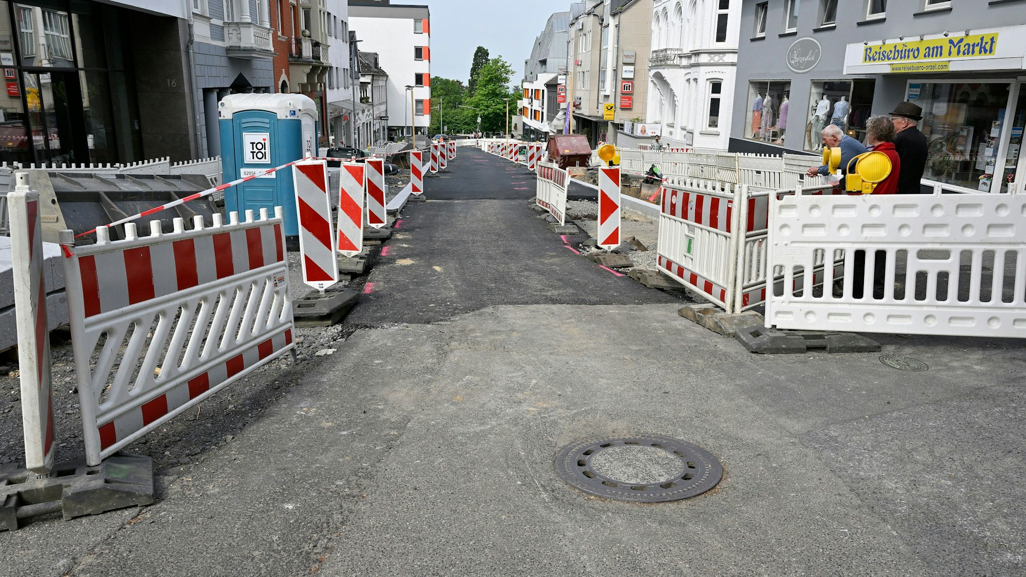 Rechts und links stehen Absperrungen, in der Mitte ist die Schloßstraße in Bensberg geteert.