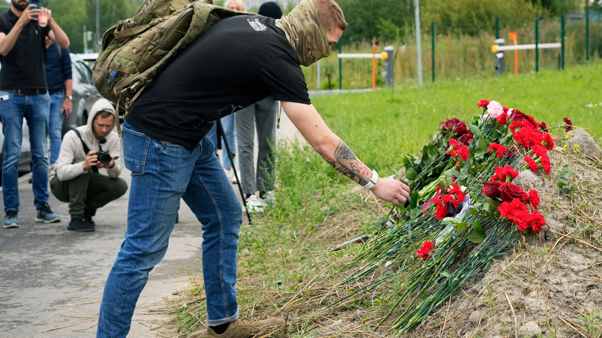 Ein Mann legt an einer informellen Gedenkstätte neben dem ehemaligen PMC-Wagner-Zentrum Blumen nieder.