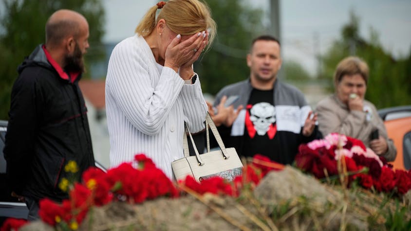 A woman reacts at an informal memorial next to the former 'PMC Wagner Centre' in St. Petersburg, Russia, Thursday, Aug. 24, 2023. Russian mercenary leader Yevgeny Prigozhin, the founder of the Wagner Group, reportedly died when a private jet he was said to be on crashed on Aug. 23, 2023, killing all 10 people on board. (AP Photo/Dmitri Lovetsky)