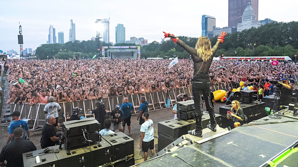 Jared Leto steht mit blonden langen Haaren vor einem großen Open-Air-Publikum und lässt sich feiern.