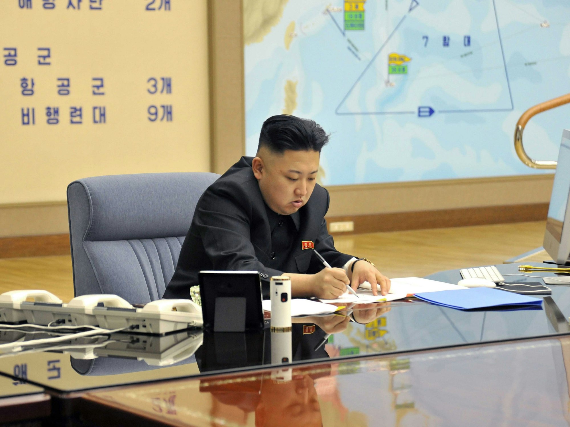 Nord Koreas Machthaber Kim Jong Un unterzeichnet Papiere.