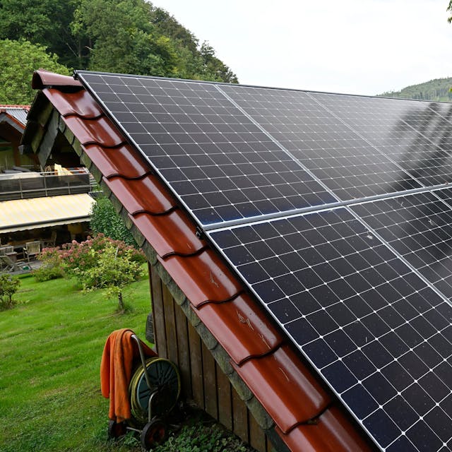 Photovoltaikanlage auf einem Dach eines kleinen Hauses.