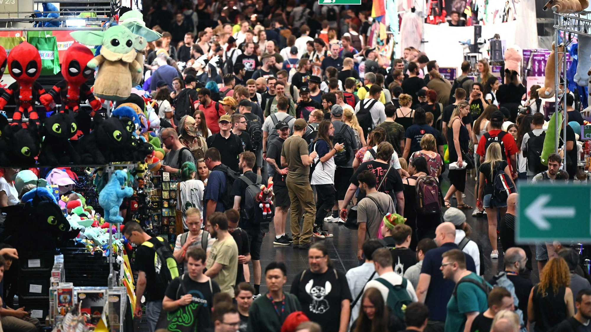 Besucher der Spielemesse Gamescom laufen durch eine der Messehallen.