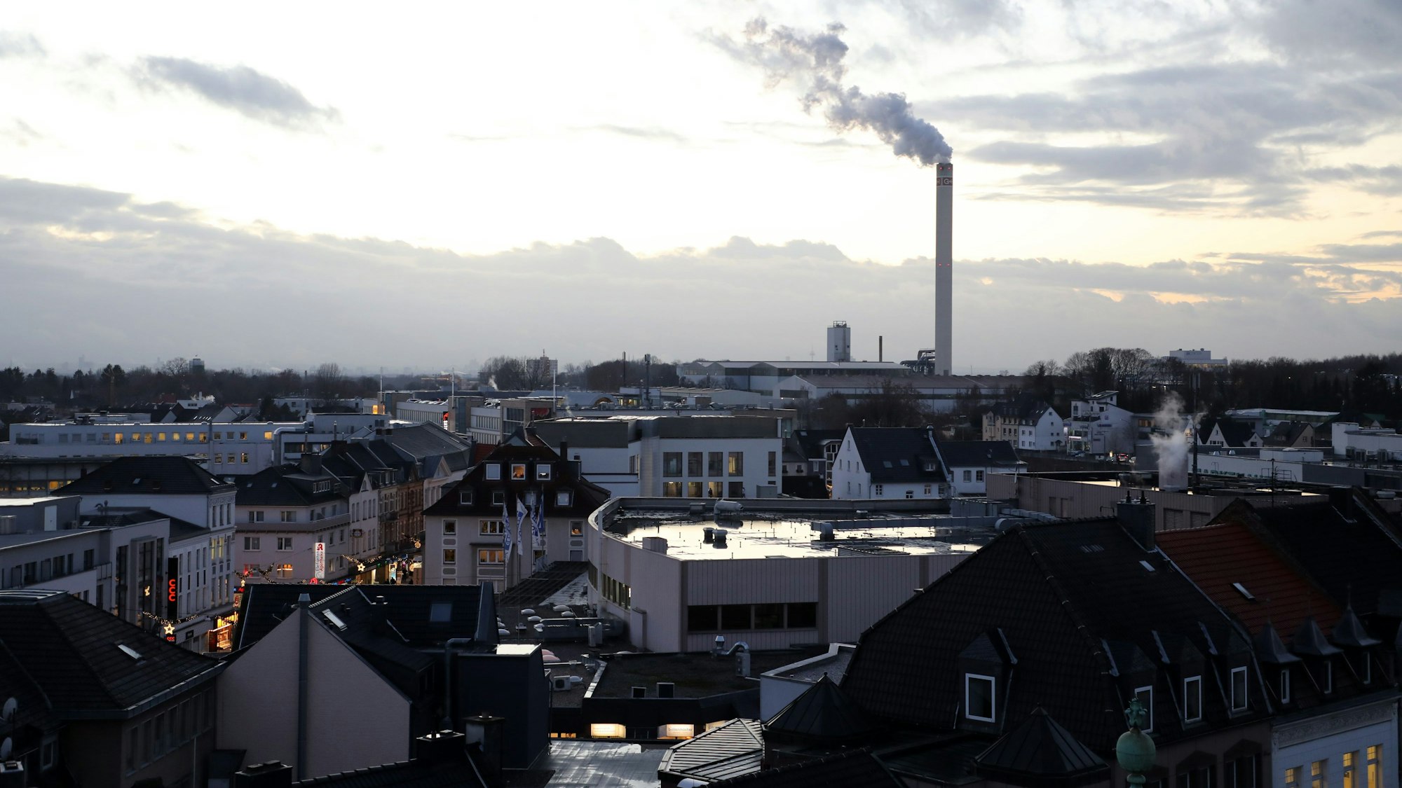 Die Innenstadt von Bergisch Gladbach, im Hintergrund ein qualmender Fabrikschornstein