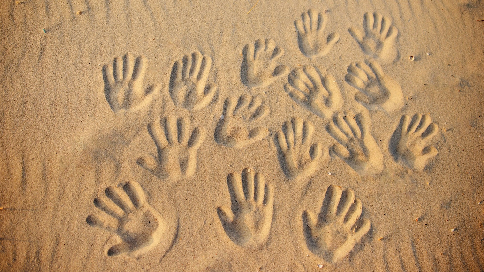 Viele Handabdrücke im Sand