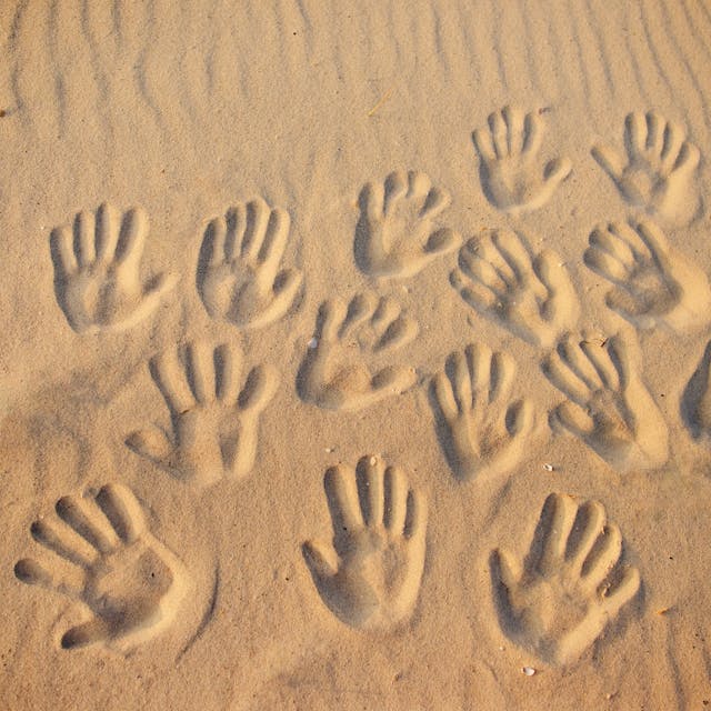 Viele Handabdrücke im Sand