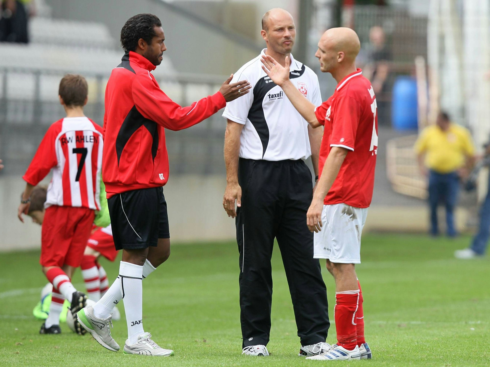 Daniel Thioune klatscht mit Teamkollege Nils-Ole Book nach dem Spiel von Rot Weiss Ahlen gegen Werder Bremen II ab. Dahinter steht Ahlen-Coach Arie van Lent.