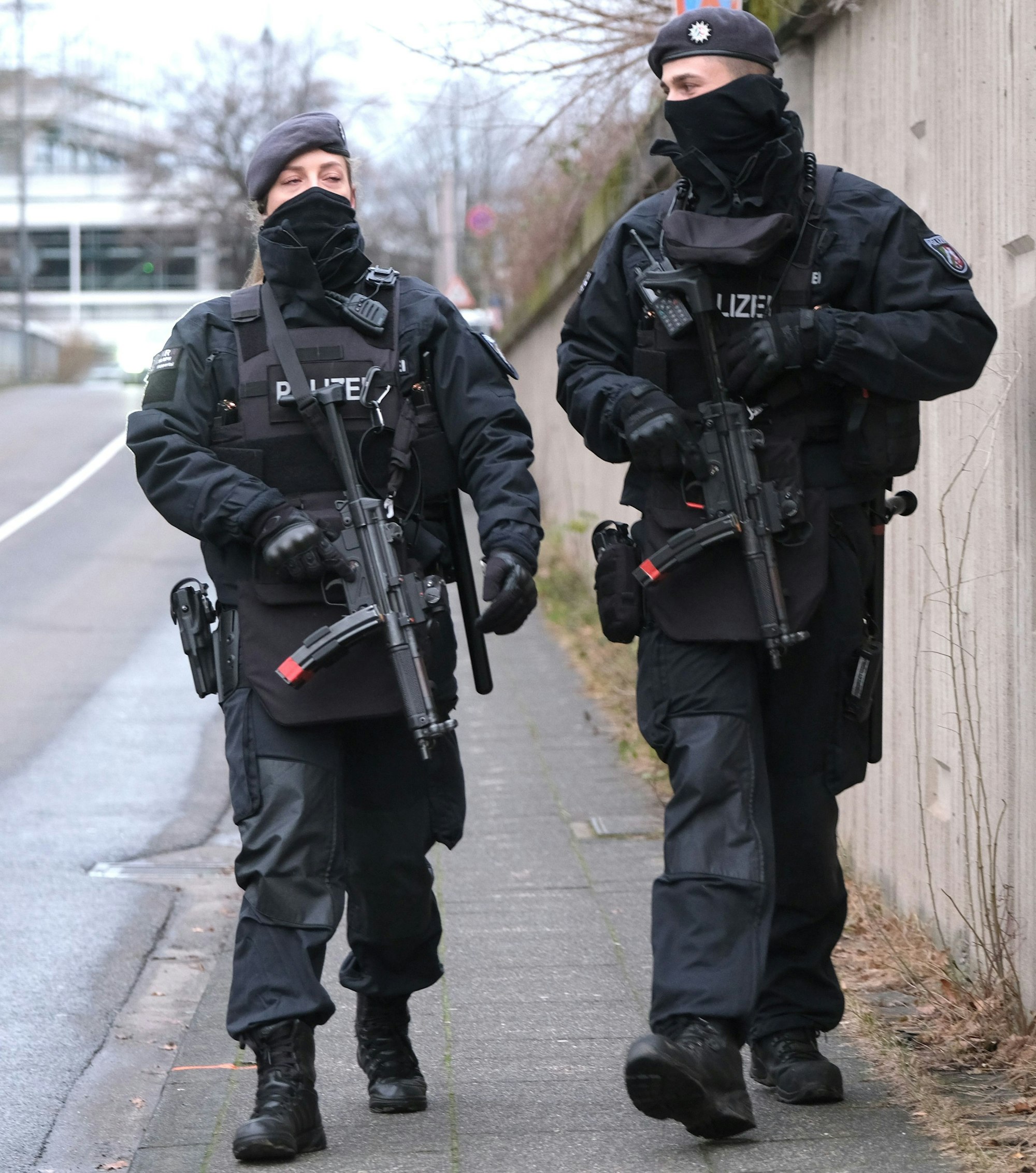 Bewaffnete Polizisten laufen Streife um das Gerichtsgebäude in Köln.