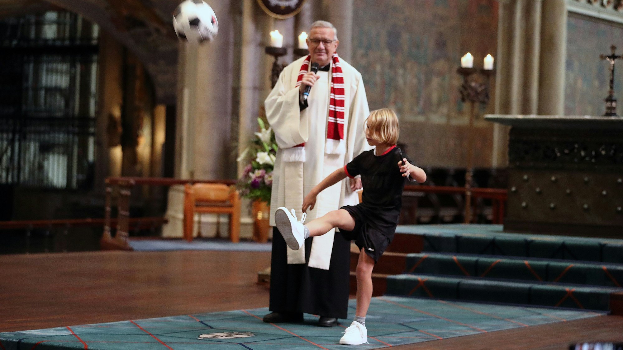 Ein Junge schießt einen Ball durch den Kölner Dom