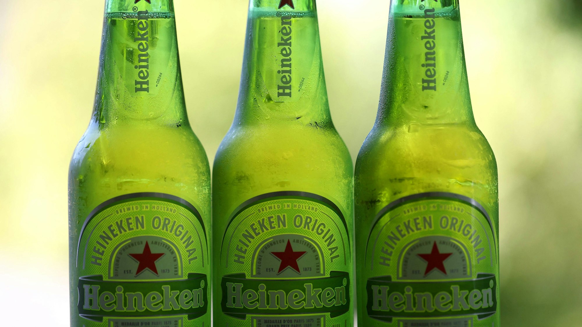 Drei grüne Heineken-Flaschen stehen nebeneinander