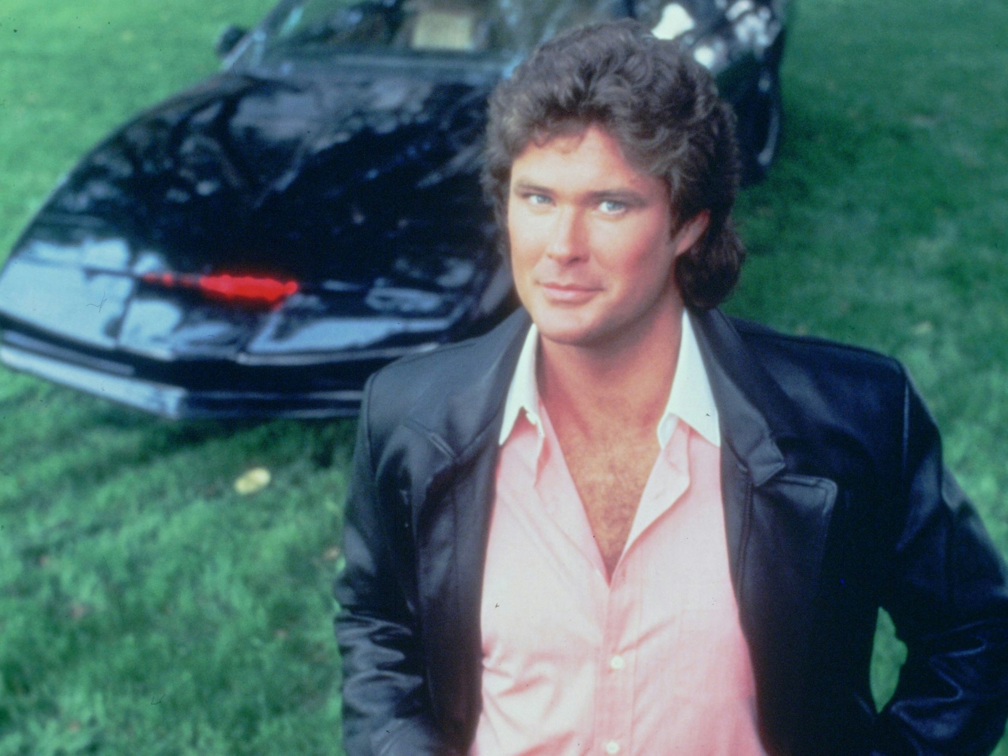 Michael Knight (David Hasselhoff) steht vor dem unzerstörbaren Wunderauto K.I.T.T. in einer Szene der Serie „Knight Rider“.