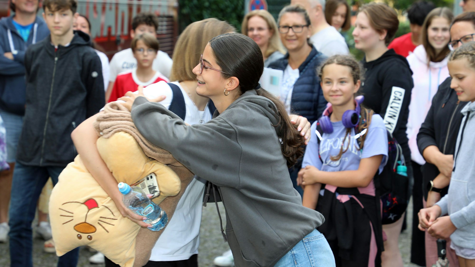 Zwei Mädchen nehmen sich zur Begrüßung in den Arm.