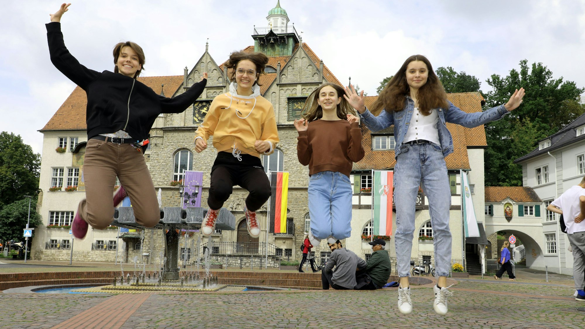 Vier Mädchen springen für die Fotoaufnahme in die Luft.