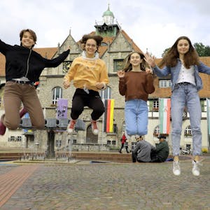 Vier Mädchen springen für die Fotoaufnahme in die Luft.